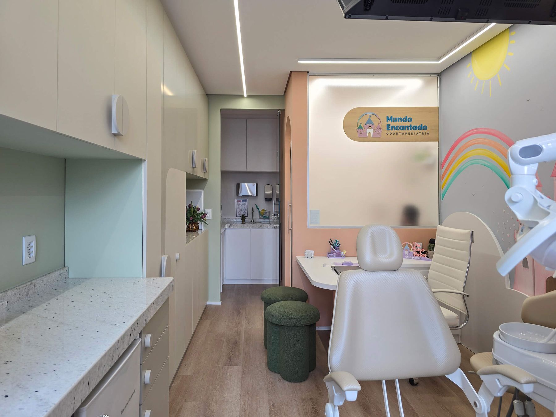 A sala vista da porta, em tons pastel e cantos arredondados